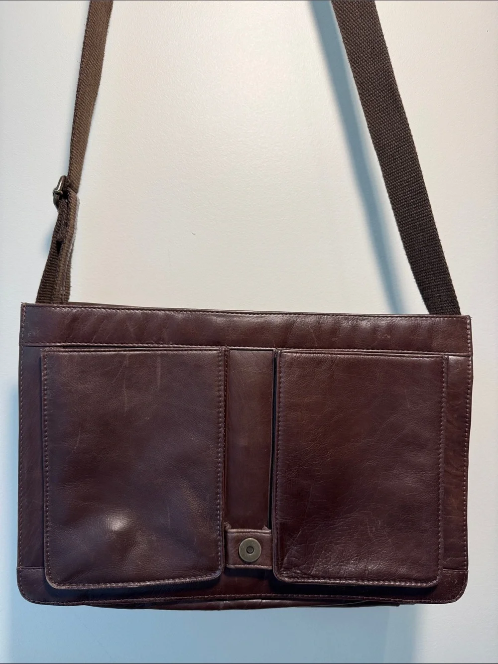 Wilson’s Leather chocolate brown messenger bag with webbed adjustable strap.